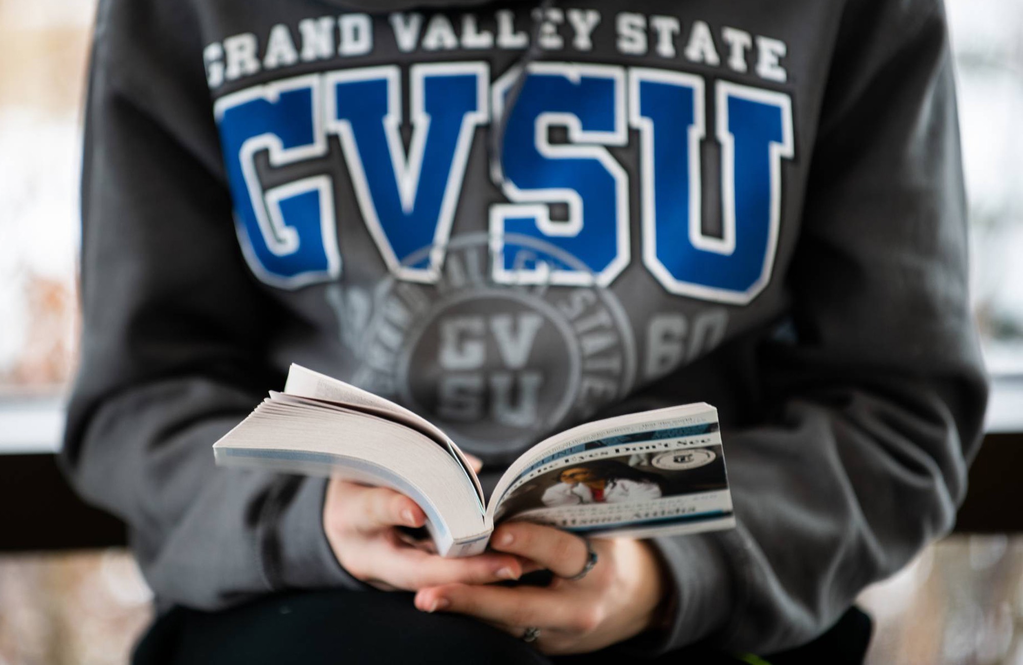 Close up a student's hand holding a book